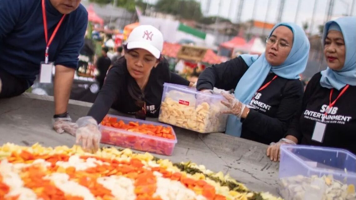 panitia sedang menata isian rujak pada cobek raksasa yang menajadi ikon festival rujak ulek suarabaya 2025